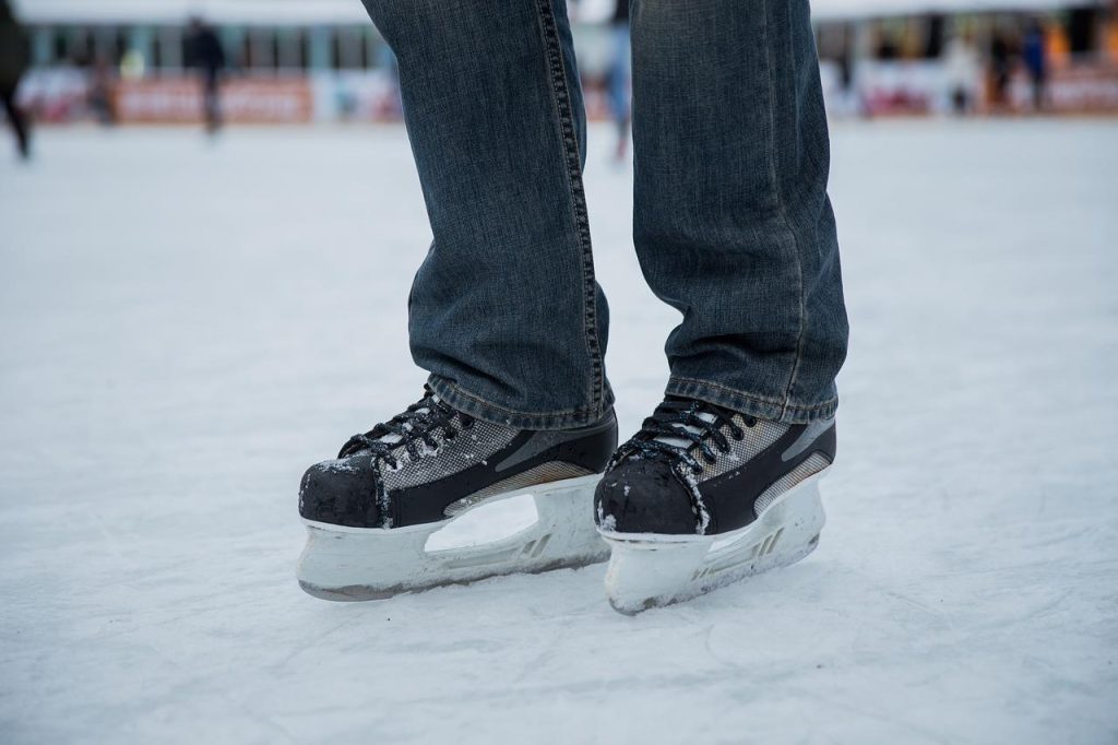 Wintersfeer bij de Ijsbaan in Drachten met schaatsers op het ijs en verwarmde kantine op de achtergrond